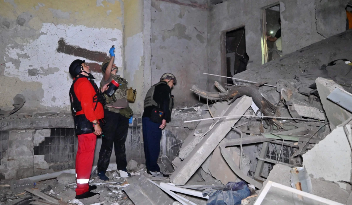 Ukrainian officers inspect damage to a residential building following a missile attack in Kharkiv. (AFP)