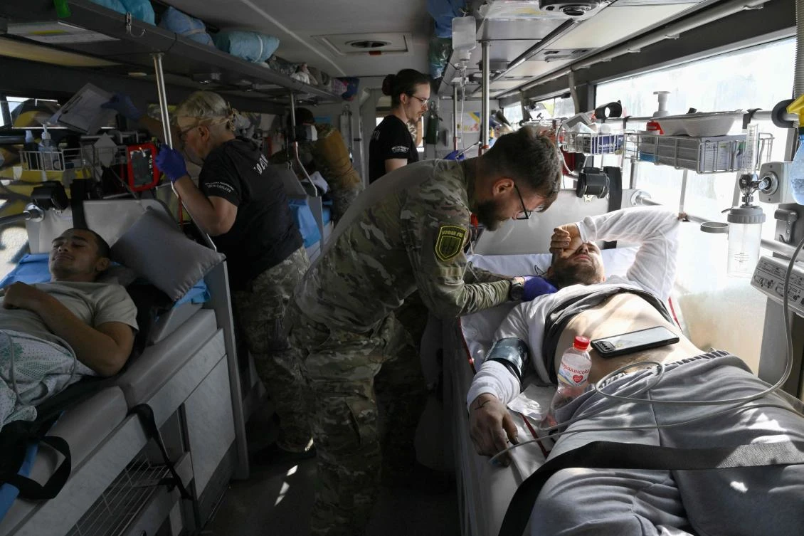 Paramedics from Ukraine’s Hospitallers organisation check on servicemen wounded in battles in the Donetsk region, now on a medical evacuation bus in an undisclosed location, as they are driven to a bigger hospital on September 23, 2024, amid the Russian invasion of Ukraine. (AFP)