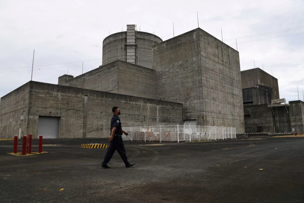 A security guard walks in front of the main gate of the Bataan Nuclear Power Plant in the town of Morong in Bataan province, north of Manila, April 5, 2022. (AFP)