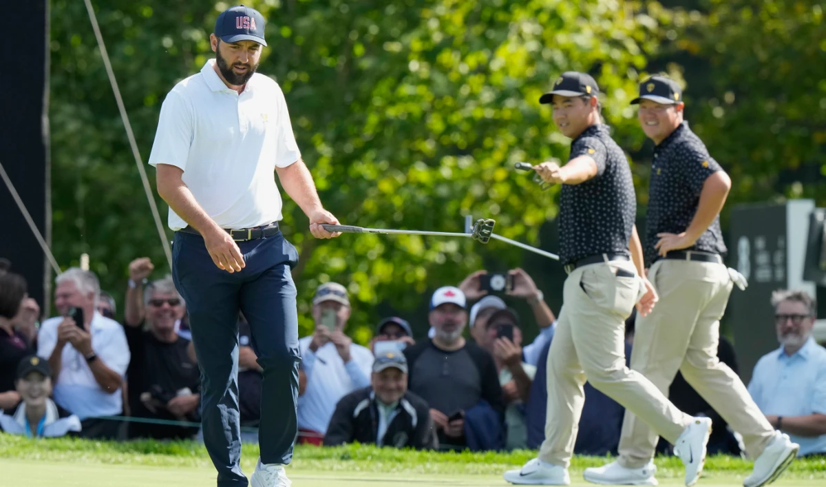 US team member Scottie Scheffler, left, after his birdie putt on the seventh hole as International team members Tom Kim, second from right, and Sungjae Im, of South Korea, congratulate him during their first round four-ball match at the Presidents Cup Thursday. (AP)