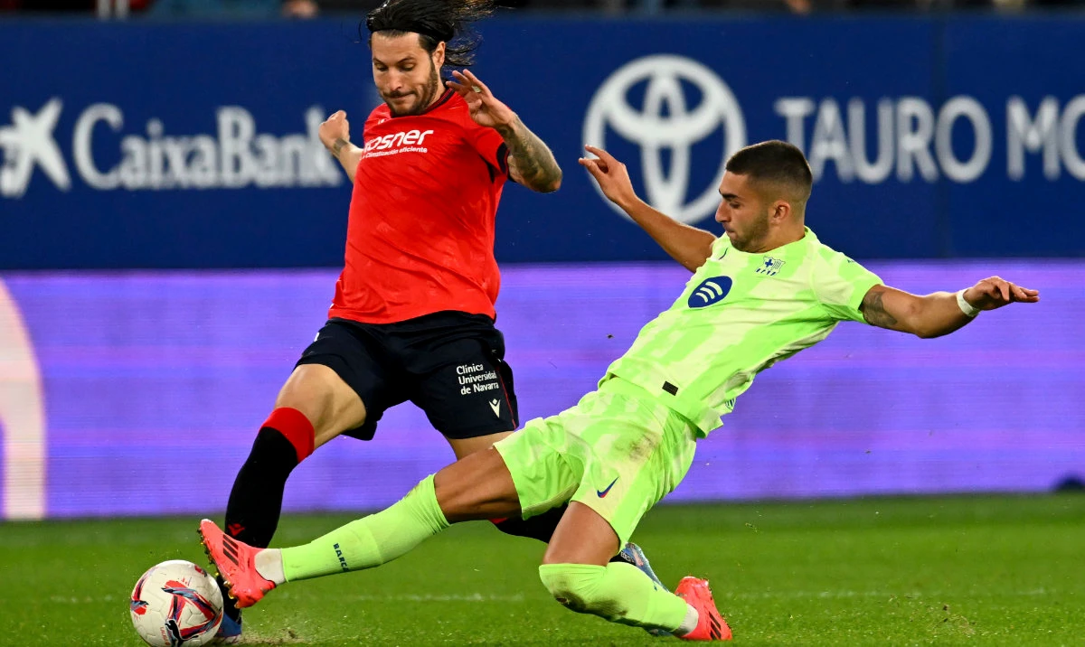 Barcelona's Ferran Torres fights for the ball against Osasuna's Juan Cruz during a Spanish La Liga soccer match between Osasuna and Barcelona at El Sadar stadium in Pamplona, Spain, Saturday, Sept. 28, 2024. (AP)