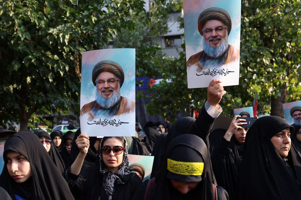 Iranian women hold pictures of Hezbollah leader Hassan Nasrallah, who was killed in an Israeli airstrike on Sept. 27. (AFP)