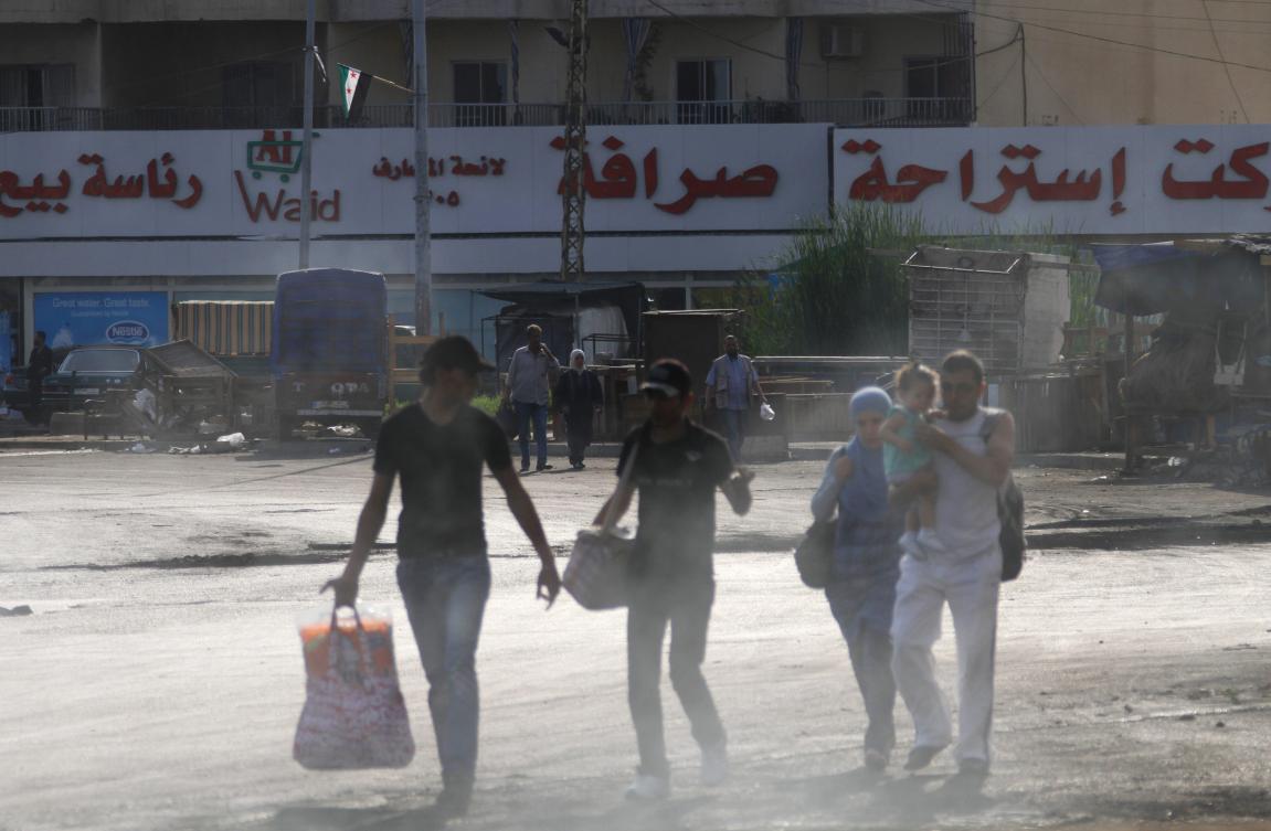 Residents carry their belongings as they flee their homes at the Bab al-Tebbaneh neighbourhood in Tripoli, northern Lebanon, early Sunday as sectoral fighting erupted overnight. (Reuters)