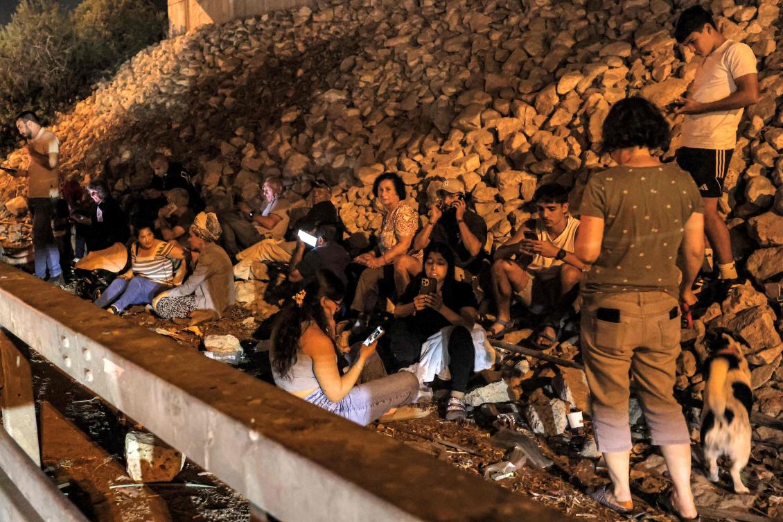 People take cover under a bridge along a highway between Kafr Qara and Baqa Al-Gharbiya in northern Israel on Oct. 1, 2024. (AFP)
