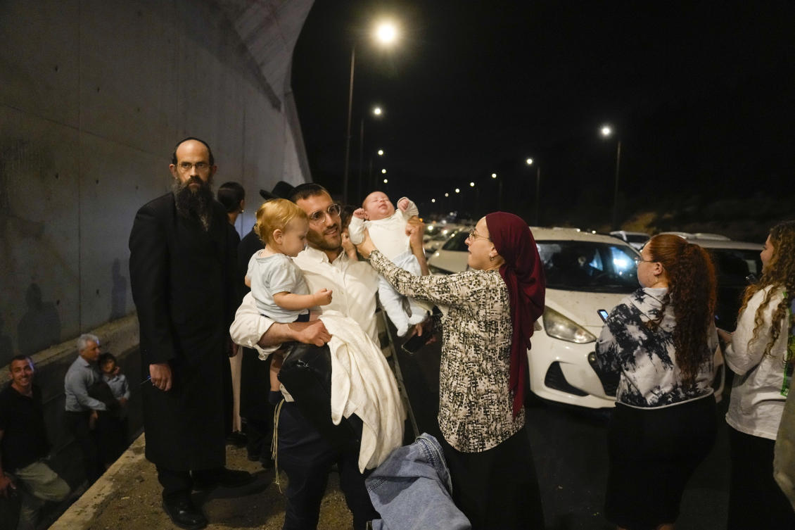 People take cover on the side of the road as a siren sounds a warning of incoming missiles fired from Iran on a freeway in Shoresh, between Jerusalem and Tel Aviv in Israel on Oct. 1, 2024. (AP)