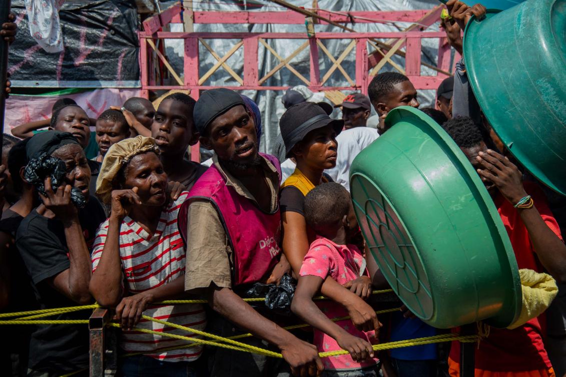 People wait for a food distribution in a displaced persons camp at the Lycée Marie Jeanne in Port-au-Prince on September 30, 2024. (AFP)