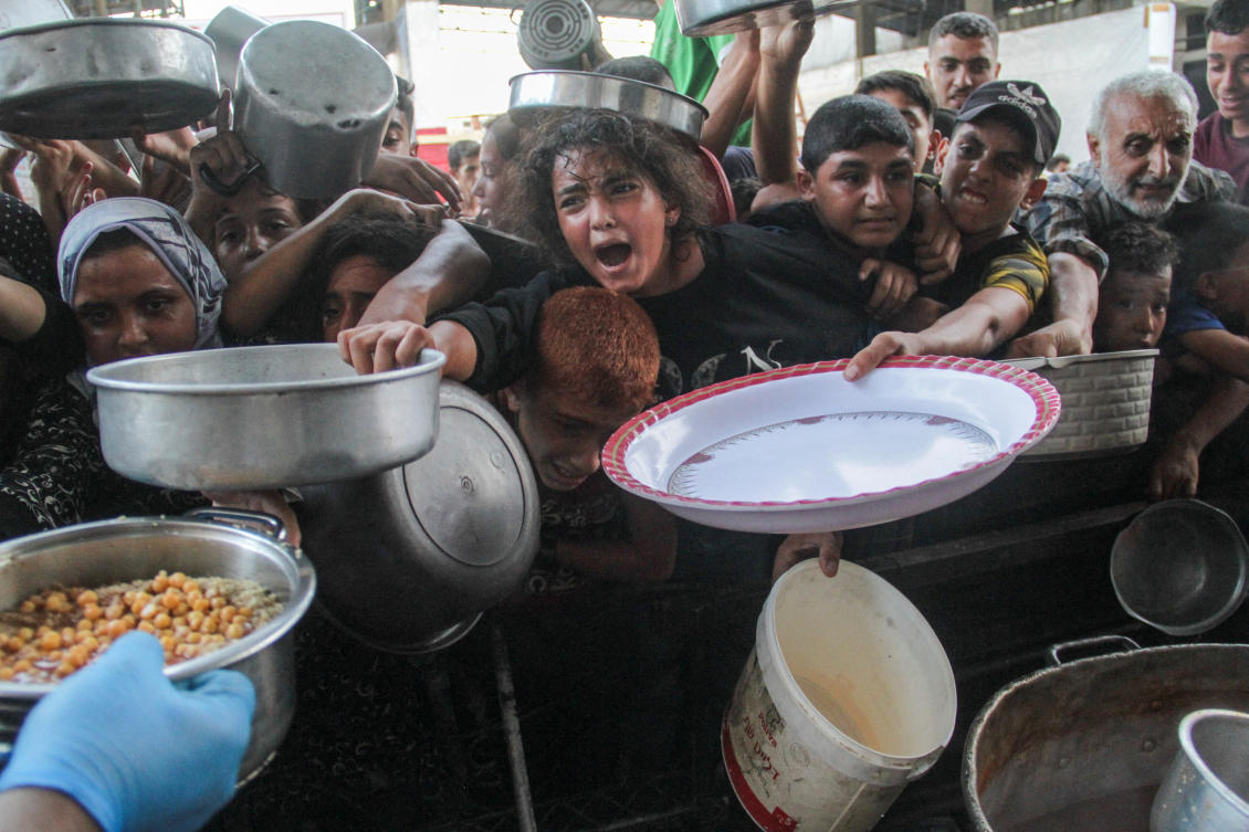 Palestinians gather to receive food cooked by a charity kitchen, amid the Israel-Hamas conflict, in the northern Gaza Strip, Sept. 11, 2024. (Reuters)