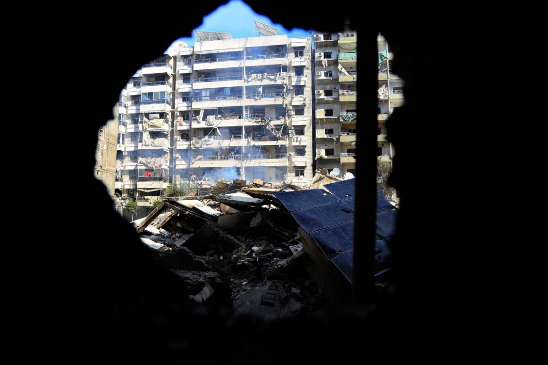 A picture taken during a tour organized by Hezbollah media office on Oct. 2, 2024 shows smoke billowing from the rubble of a building destroyed in an Israeli airstrike on a neighborhood in Beirut’s southern suburbs. (AFP)