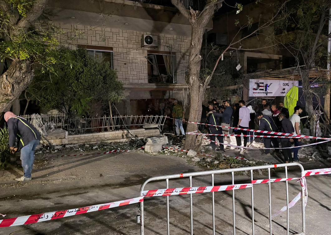 People stand at the site of an Israeli airstrike that targeted a residential building in the Mezzah suburb in western Damascus, according to Syrian state media on Oct. 2, 2024. (Reuters)