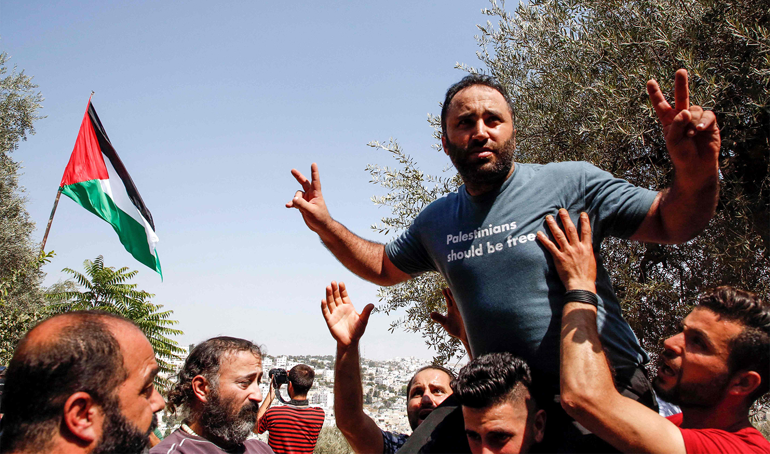 Prominent Palestinian activist Issa Amro is welcomed by supporters after he was released on bail by a Palestinian court, in the West Bank city of Hebron on September 10, 2017, following his prior arrest on September 4. (AFP/File)