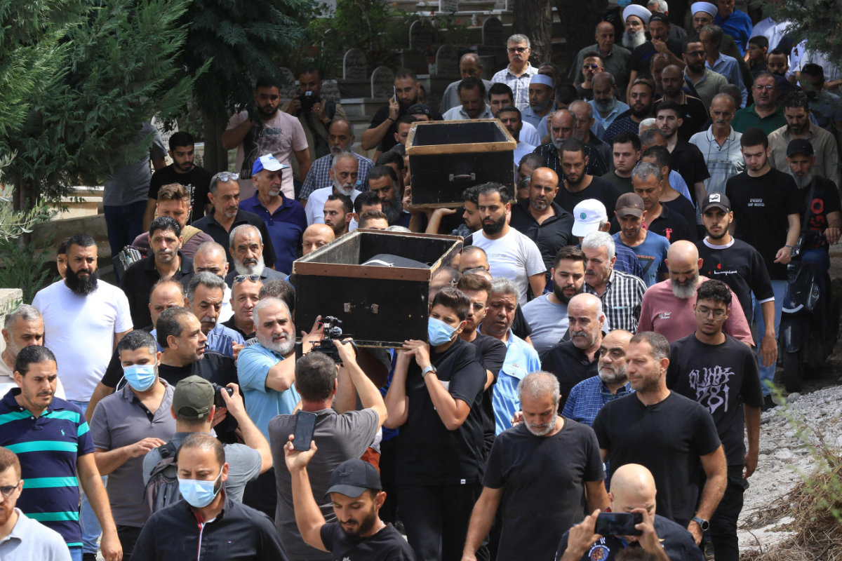 Mourners march to a cemetery in the city of Sidon in southern Lebanon on October 1, 2024 with the bodies of victims of an Israeli air strike on the town of Ain al-Delb. Lebanon's health ministry said on September 30 that 45 people were killed and 70 wounded in the bombardment of Ain al-Delb. (AFP)
