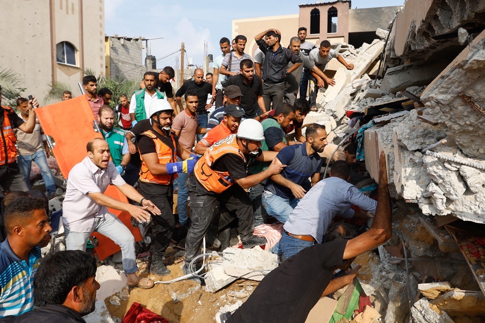 Palestinians search under the rubble of a house destroyed in Israeli strikes in Khan Younis, in the southern Gaza Strip, October 8. (Reuters/File)
