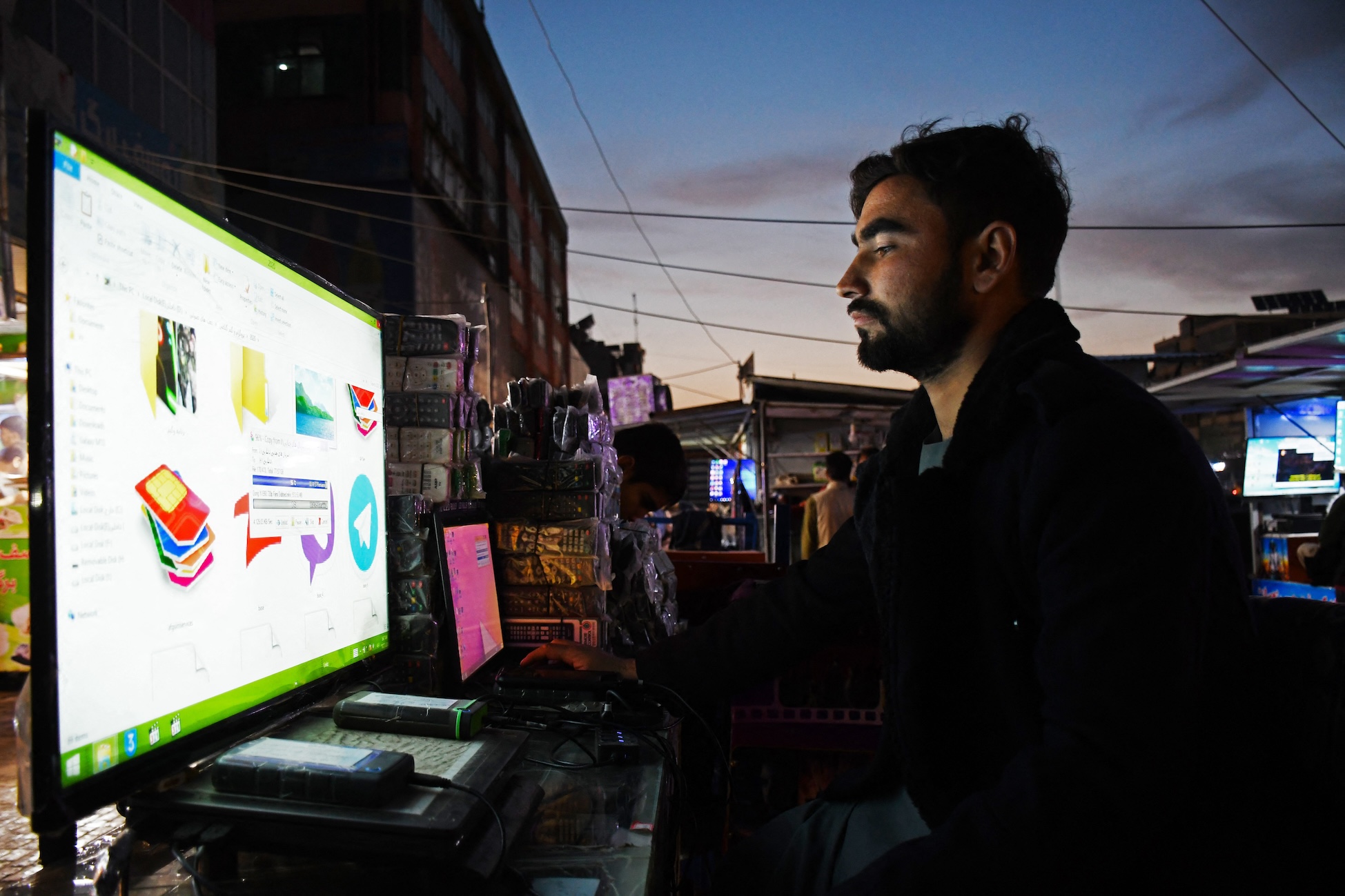 An Afghan man uses a computer at a market in Mazar-i-Sharif on Oct. 17, 2023. (AFP)