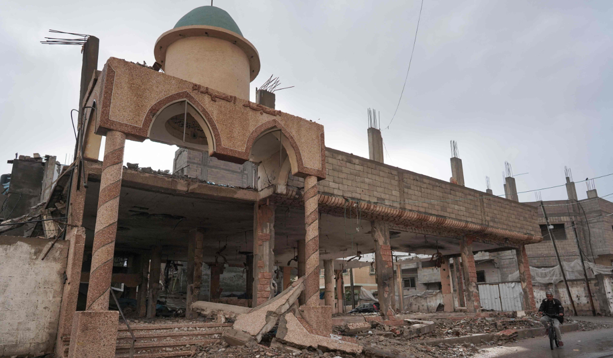 A Palestinian man bikes past a destroyed mosque in Deir Al-Balah in the central Gaza Strip on April 10, 2024. (AFP file photo)
