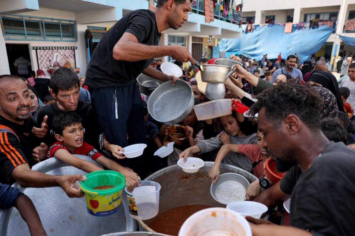 Palestinian children receive food at a UN-run school in Rafah, on the southern Gaza Strip on October 23, 2023 amid ongoing battles between Israel and Hamas militants. (AFP)