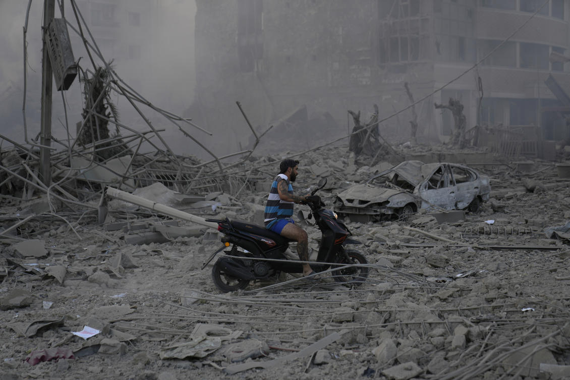 A man rides his scooter as he drives on the debris of destroyed buildings that were hit by Israeli airstrikes in Dahiyeh, Beirut, Lebanon, Sunday, Oct. 6, 2024. (AP)