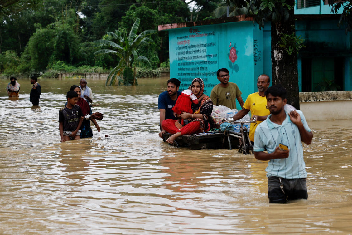 People move a cart with a woman and a child through a flooded street, amid severe flooding in the Fazilpur area of Feni, Bangladesh, August 26, 2024. (Reuters)
