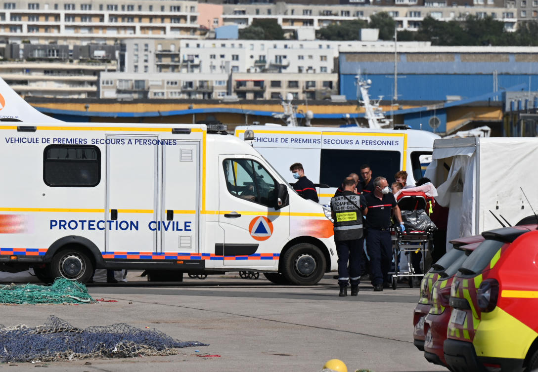Firefighters provide assistance to an injured migrant after a vessel carrying dozens trying to cross the Channel to England sank off the northern French coast. (File/AFP)