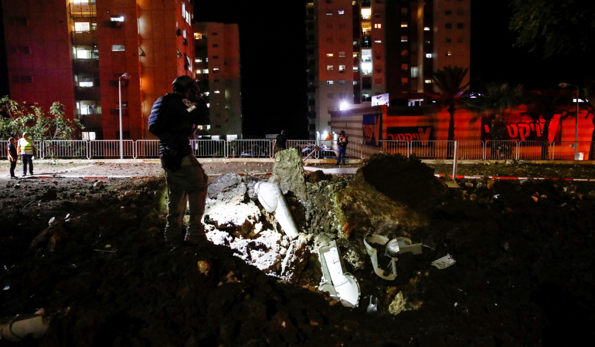 An Israeli rescue force member inspects the site where a projectile fell,amid cross-border hostilities between Hezbollah and Israel, in Haifa, northern Israel October 6, 2024. (REUTERS)