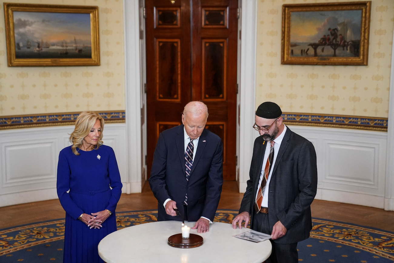 US President Joe Biden, flanked by first lady Jill Biden and Rabbi Aaron Alexander of Adas Israel Congregation, lights a candle to mark the anniversary of the Oct. 7 attacks on Israel. (Reuters)
