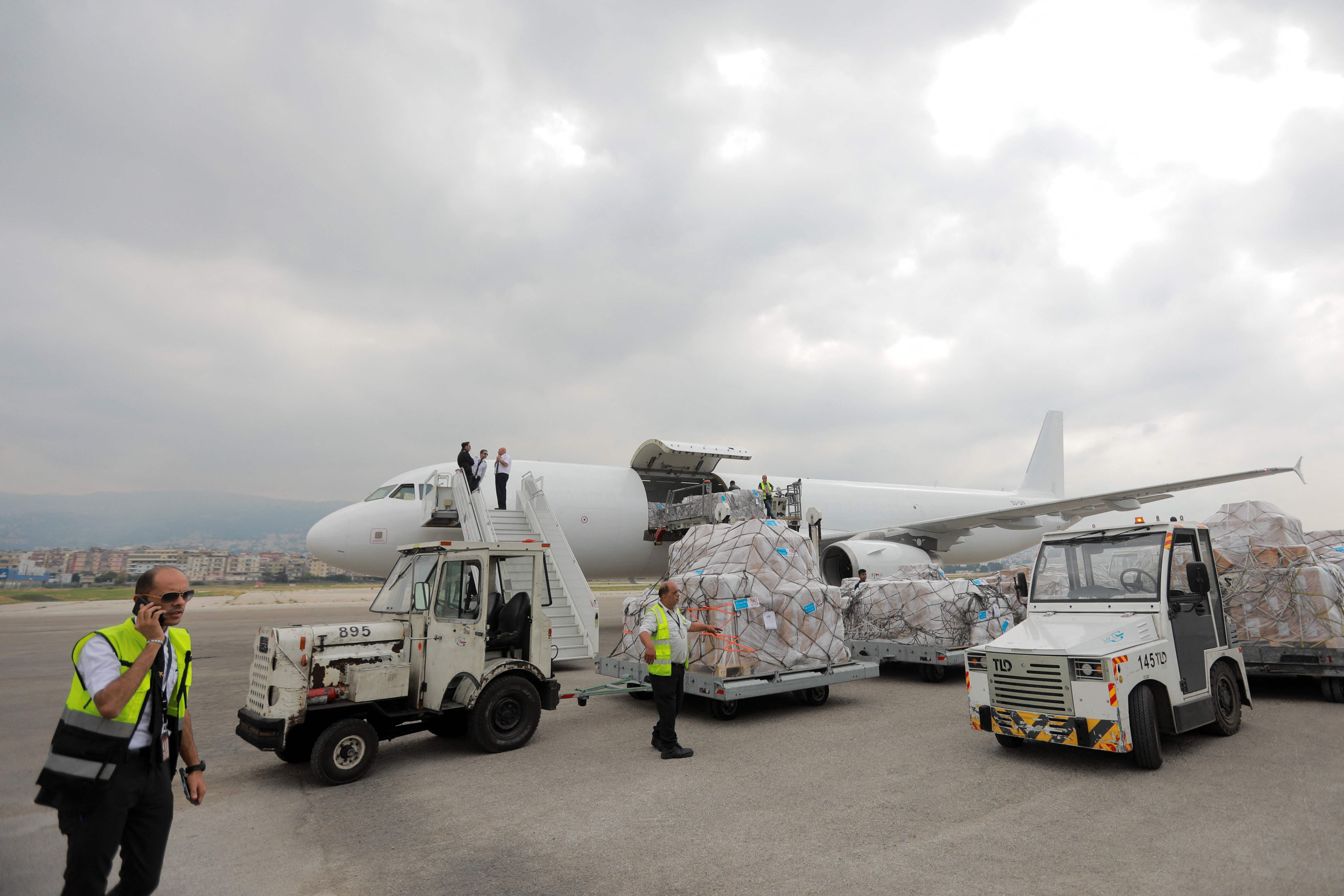 Aid workers supervise as airport workers unload humanitarian aid provided by UK Aid and theUNICEF at Beirut International airport on Sunday. AFP