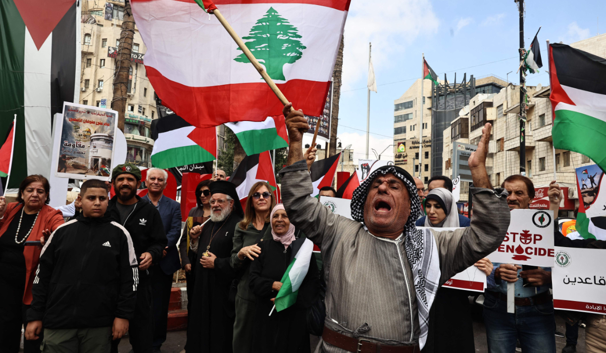 Protesters carry Lebanese flags during a rally to mark the anniversary of Palestinian militant group Hamas's October 7, 2023 attack on Israel, in Ramallah in the occupied West Bank on October 7, 2024. (AFP)