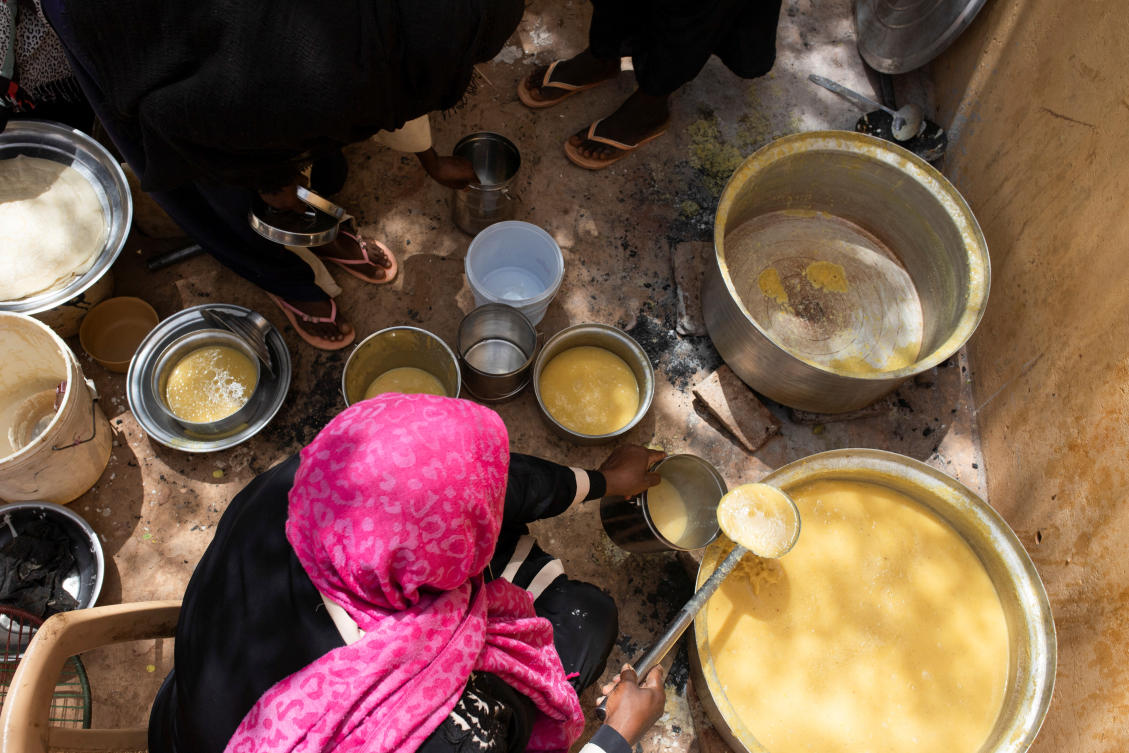 A Sudanese woman from a community kitchen, run by local volunteers, prepares a meal for people who are affected by conflict and extreme hunger and are out of reach of international aid efforts, in Omdurman. (Reuters)