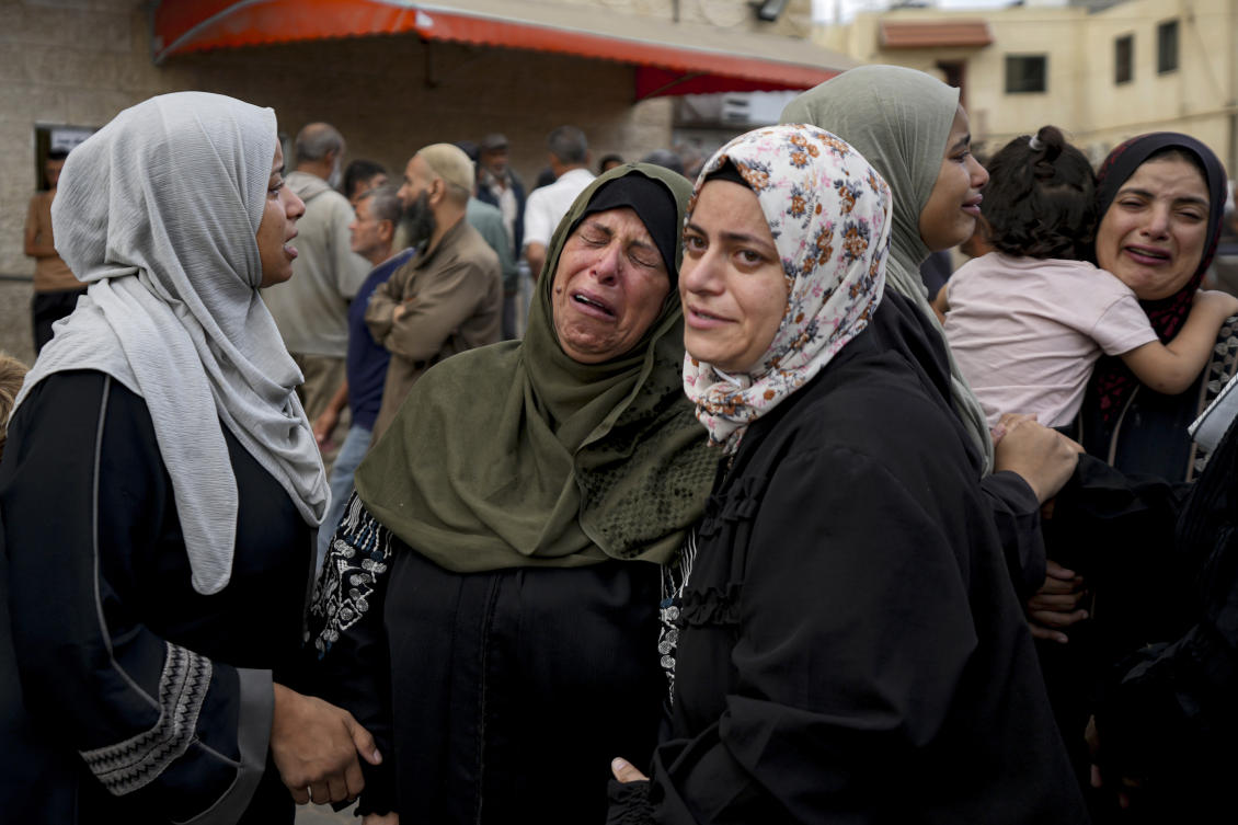 Palestinians mourn their relatives killed in the Israeli bombardment of the Gaza Strip at a hospital in Deir al-Balah. (AP)