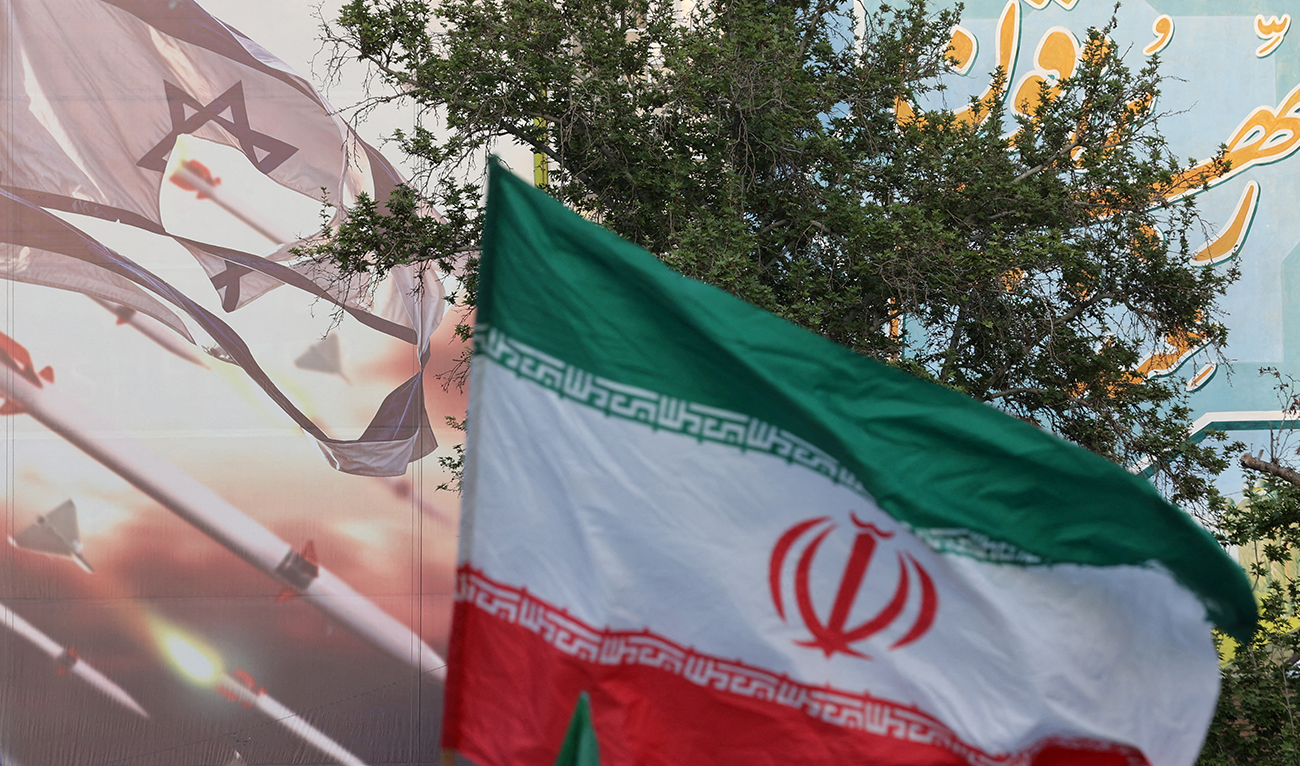 An anti-Israel billboard is seen next to the Iranian flag during a celebration following the IRGC attack on Israel, in Tehran, Iran, April 15, 2024. (REUTERS/File)