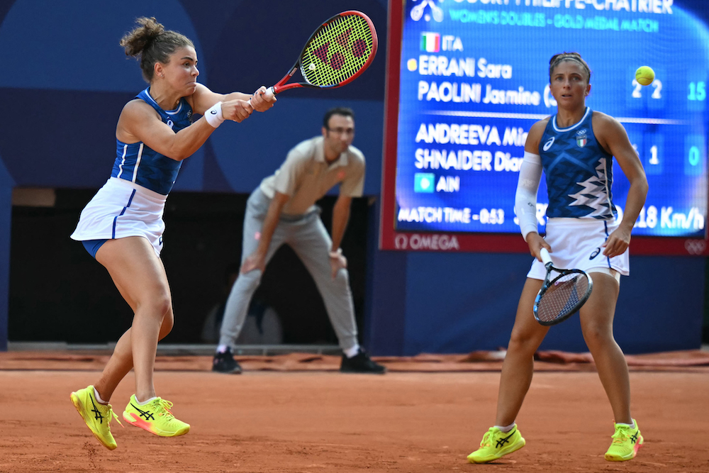 Italy’s Jasmine Paolini, left, returns a play with Sara Errani during their women’s doubles gold medal match against Individual Neutral Athletes Mirra Andreeva and Diana Shnaider during the Paris 2024 Olympic Games on Aug. 4, 2024. (AFP)