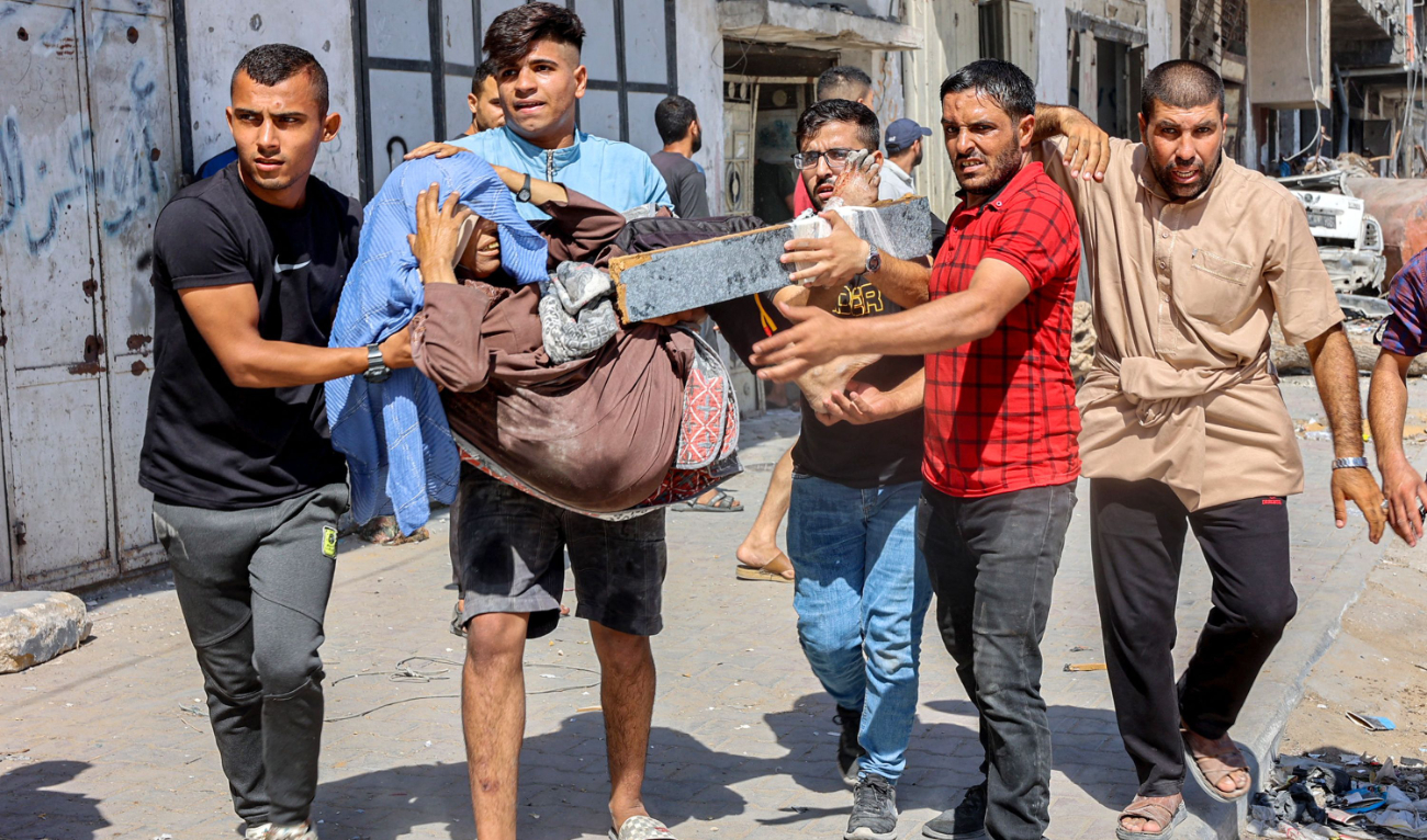 Men carry injured woman to be evacuated in the Jabalia camp for Palestinian refugees in the northern Gaza Strip on October 9. (AFP)