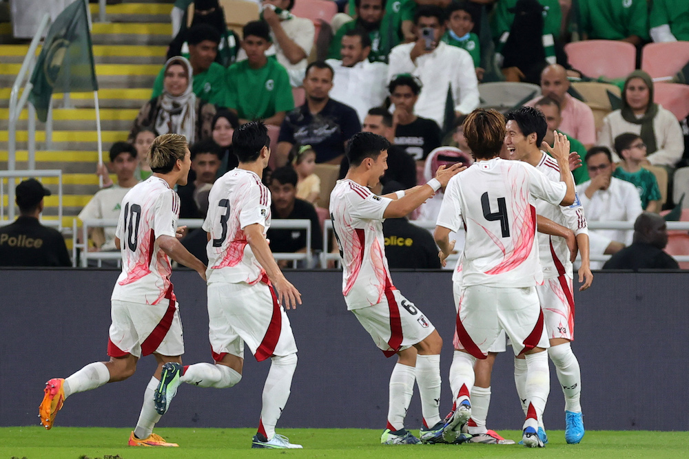 Japan’s players celebrate after their first goal during their 2026 FIFA World Cup Asian qualification match against Saudi Arabia at King Abdullah Sports City in Jeddah on Oct. 10, 2024. (AFP)
