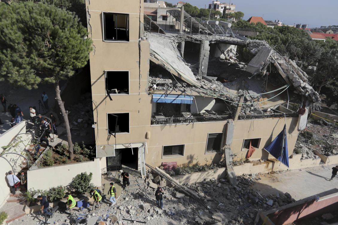 Rescue workers walk outside a hotel-turned-shelter for displaced people hit by an Israeli airstrike, in Wardaniyeh, south Lebanon, Oct. 9, 2024. (AP)