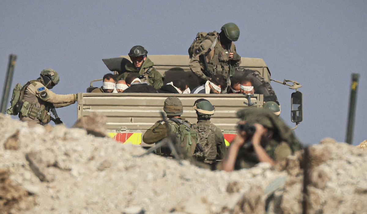 Israeli soldiers detain blindfolded Palestinian men in a military truck in the southern part of the Gaza Strip on November 19, 2023. (AFP file photo)