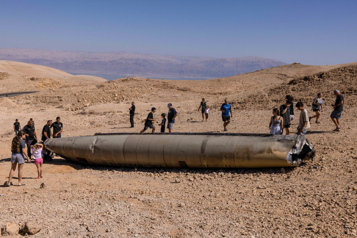 Israelis inspect what remains of an Iranian missile in the Negev desert near Arad on October 3, 2024, in the aftermath of an Iranian missile attack on Israel. (AFP)