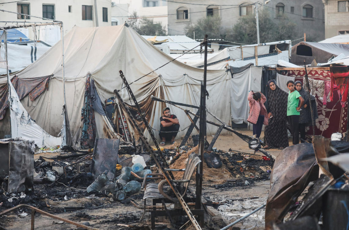 Palestinians survery the damage at the site of an Israeli strike on tents sheltering displaced people, amid the Israel-Hamas conflict, at Al-Aqsa Martyrs hospital in Deir Al-Balah in the central Gaza Strip. (REUTERS)
