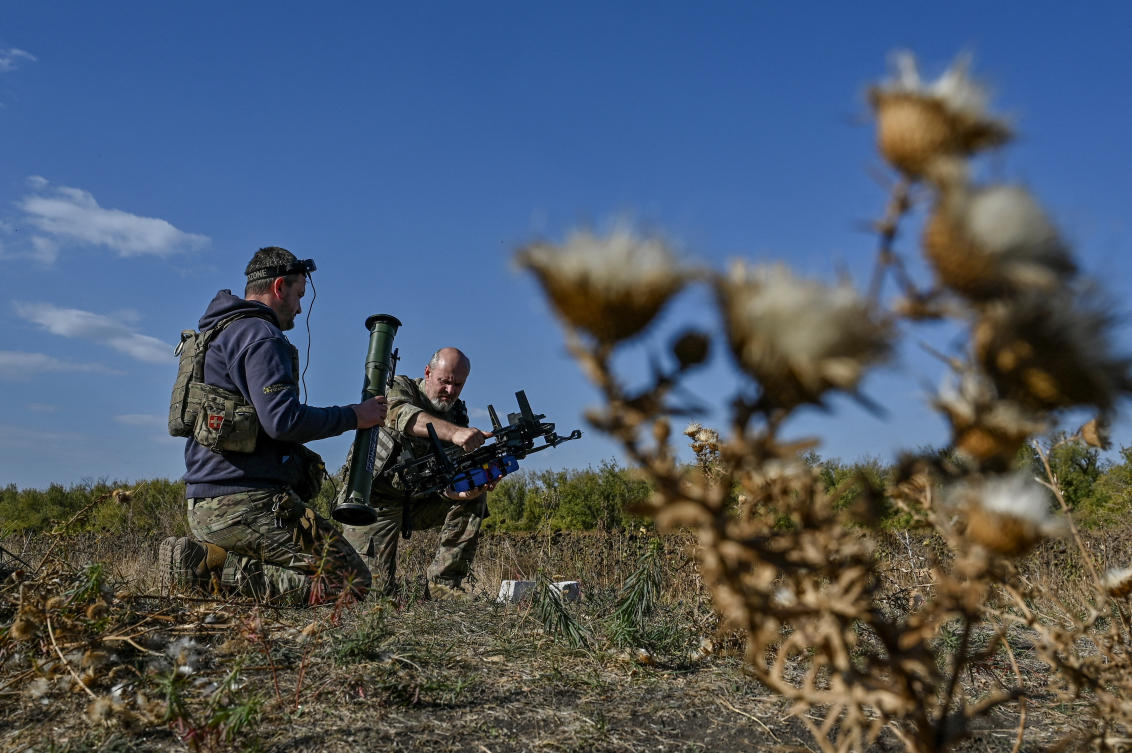 Ukrainian servicemen of the 'Bulava' Unmanned Aerial Vehicles Unit of the Separate Presidential Brigade attach a portable grenade launcher to an FPV drone before a test fly at their position near a frontline, amid Russia's attack on Ukraine, in Zaporizhzhia region, Ukraine October 11, 2024. (Reuters)