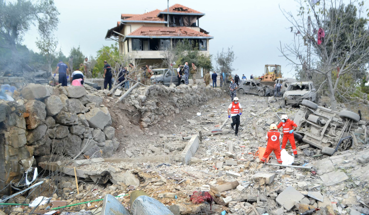 Paramedics with the Lebanese Red Cross unearth a body from the rubble at the site of an Israeli airstrike that targeted the northern Lebanese village of Aito on October 14, 2024. (AFP)