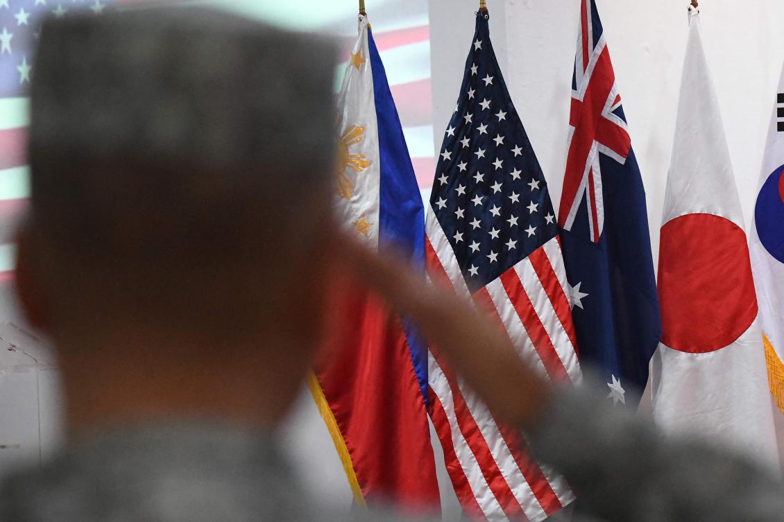 A Philippine Marine salutes in front of US, Philippine, Australia, Japan and South Korea flags during the opening ceremony of the Kamandag 2024 joint military exercise in Manila on Oct. 15, 2024. (AFP)