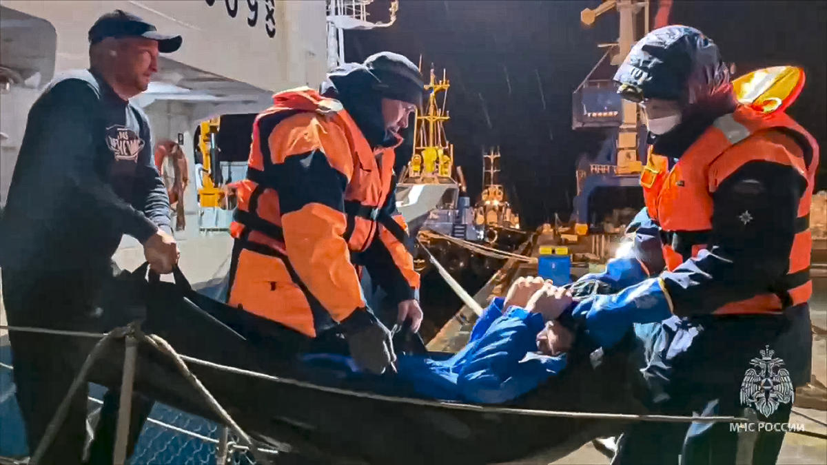 Russian emergency workers pull Mikhail Pichugin ashore after he was rescued by a fishing vessel following 67 days adrift in the Sea of Okhotsk in Kamchatka region of Russian far east. (Russian Emergency Ministry Press Service via AP)