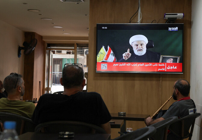 Above, people watch Hezbollah deputy leader Sheikh Naim Qassem delivering a televised address as they sit in a cafe in Beirut on Oct. 15, 2024. (Reuters)