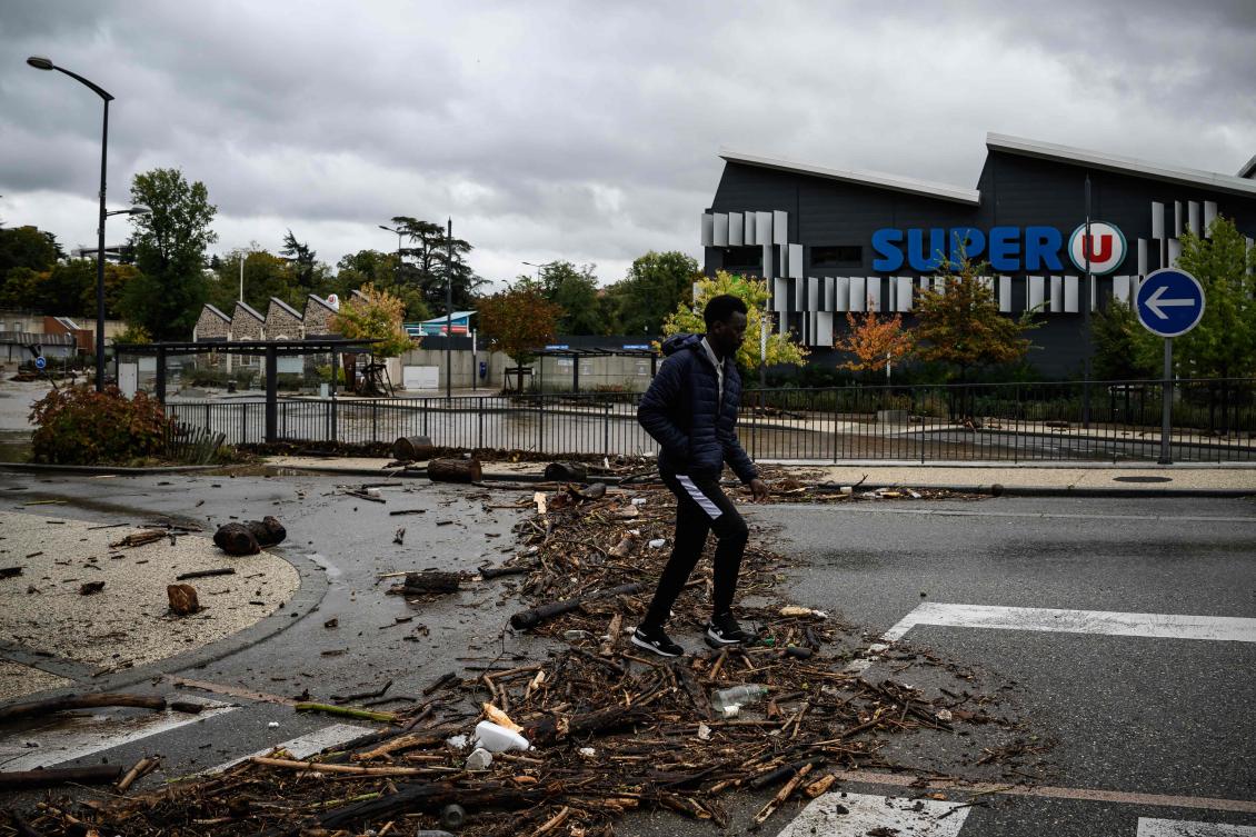 A pedestrian walks past debris on a street caused by flooding following heavy rainfall in Annonay, central France, on Oct. 17, 2024. (AFP)