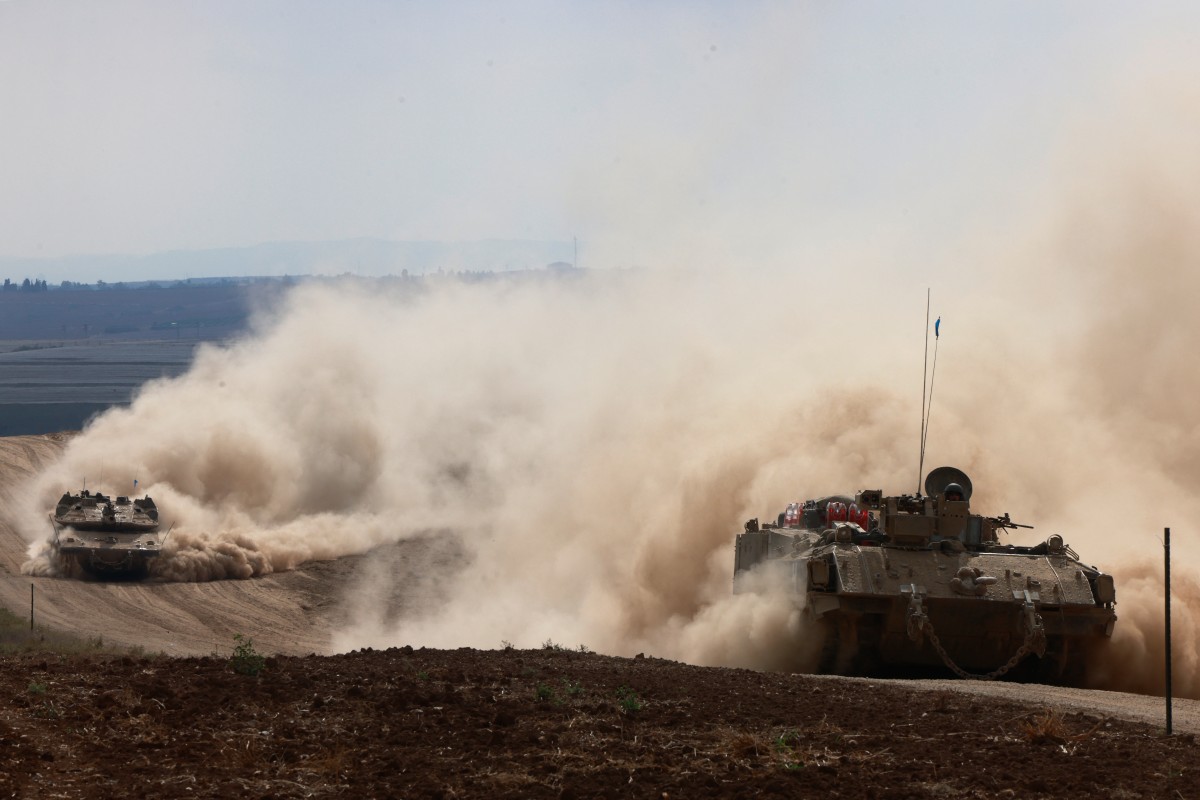 Israeli army tanks drive in an area near Israel's southern border with the Gaza Strip on October 6, 2024.(AFP)