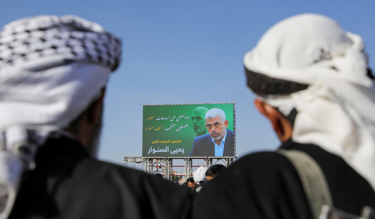People stand in front of the billboard showing late Hamas leader Yahya Sinwar as protesters, mainly Houthi supporters, rally to show support to Lebanon's Hezbollah and Palestinians in the Gaza Strip, in Sanaa, Yemen October 18, 2024. (REUTERS)