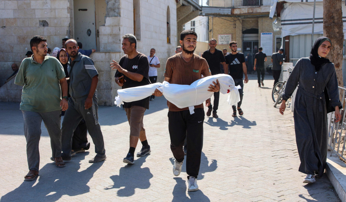 A relative carries the shrouded body of ten-year-old Sama al-Debs, who was killed during an Israeli army operation in the Jabalia refugee camp in the central Gaza Strip, ahead of her funeral on October 18, 2024, amid the continuing war between Israel and the Palestinian militant group Hamas. (AFP)