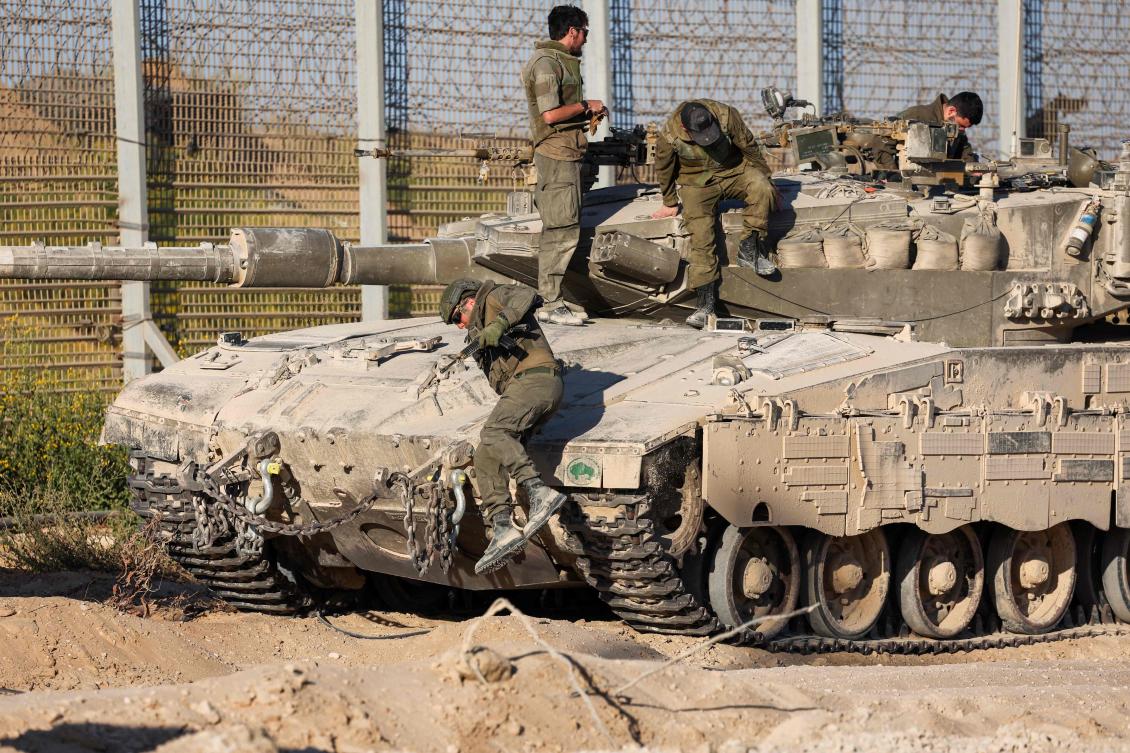 TOPSHOT - Israeli soldiers disembark from a tank as they patrol along the Israel-Gaza border area on October 21, 2024, amid the ongoing war between Israel and the Hamas militant group. (Photo by Jack GUEZ / AFP)