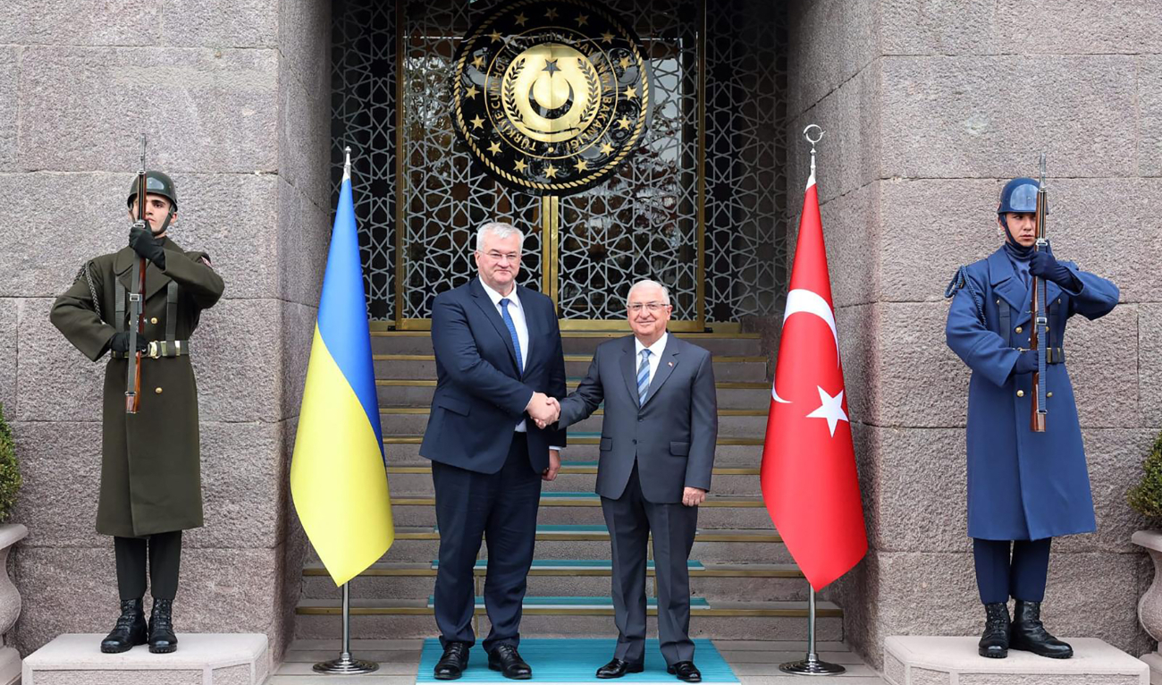 This handout photograph taken and released by the Turkish Defence Ministry on October 21, 2024, shows Turkiye’s Defence Minister Yasar Guler (R) shaking hands with Ukraine's Foreign Minister Andrii Sybiha in Ankara. (AFP)