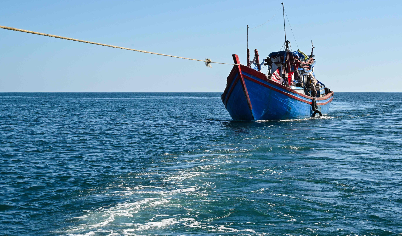 A boat with Rohingya refugees is pulled by a relief vessel to anchor closer to shore off the coast of Labuhan Haji in Southern Aceh province on October 21, 2024. (AFP)