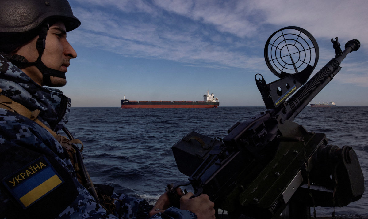 A serviceman of Ukraine's coast guard mans a gun on a patrol boat as a cargo ship passes by in the Black Sea, amid Russia’s attack on Ukraine. (Reuters/File)