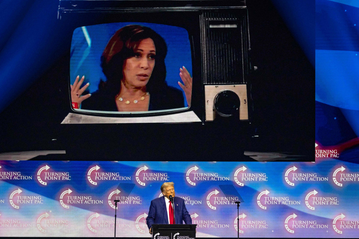 Former US President and Republican presidential candidate Donald Trump shows videos of US Vice President and democratic presidential candidate Kamala Harris during a campaign event at Gas South Arena in Duluth, Georgia, on October 23, 2024. (AFP)